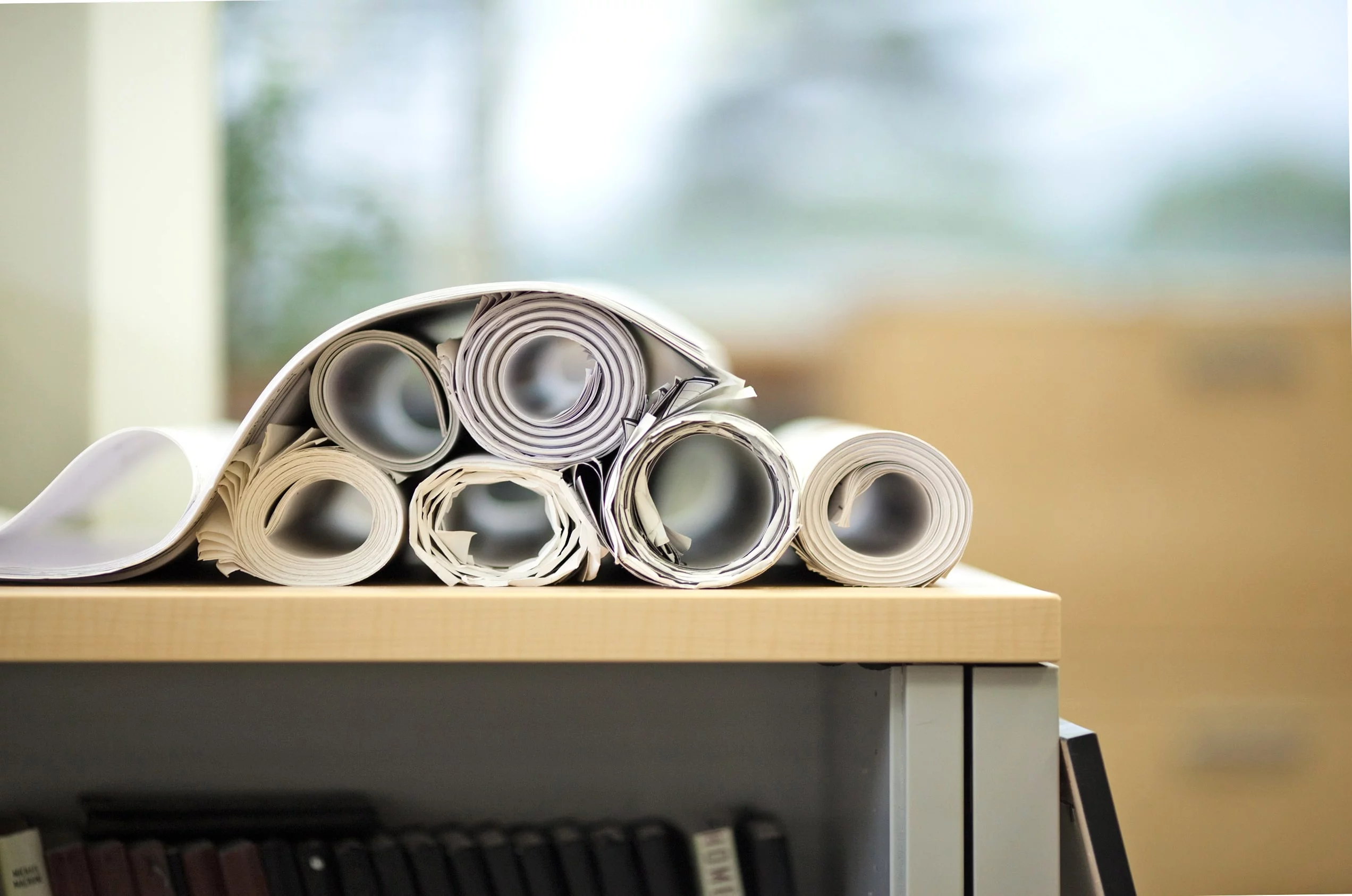 Rolled up blueprints on a table.